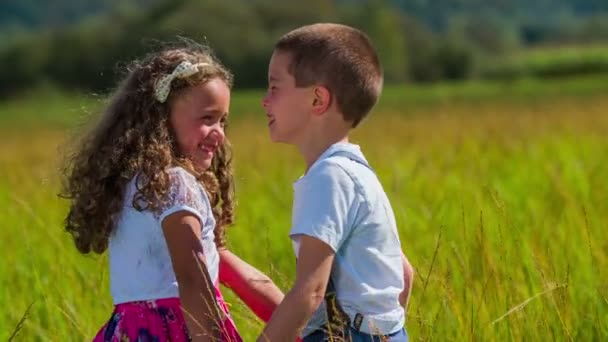 Kinder halten sich an den Händen, lächeln und drehen sich - Filmmaterial, Video