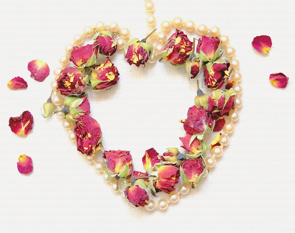 sanfter Hintergrund mit rosa Rosenknospe, Rosenblättern und herzförmiger Perlenkette isoliert auf weiß. - Foto, Bild