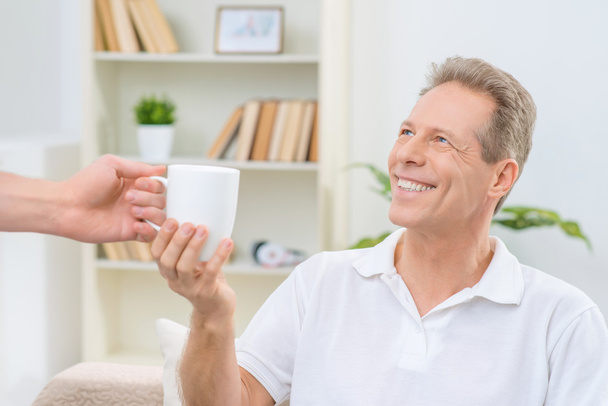 Senior man holding cup of  tea - Foto, imagen
