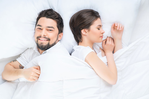 Ωραίο ζευγάρι ερωτευμένων ξαπλωμένη στο κρεβάτι - Φωτογραφία, εικόνα