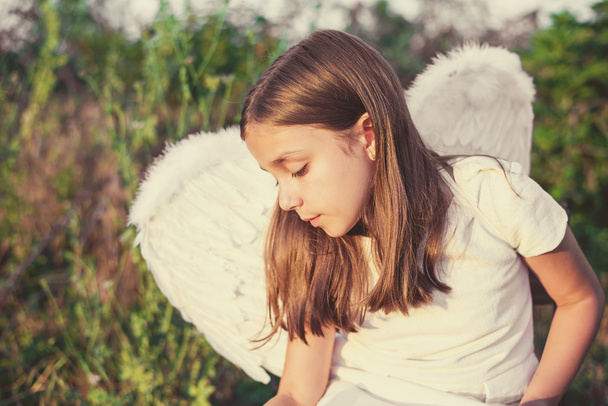 Menina com asas de anjo e vestido branco
 - Foto, Imagem