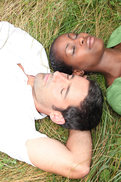 Couple lying in grass - Foto, afbeelding