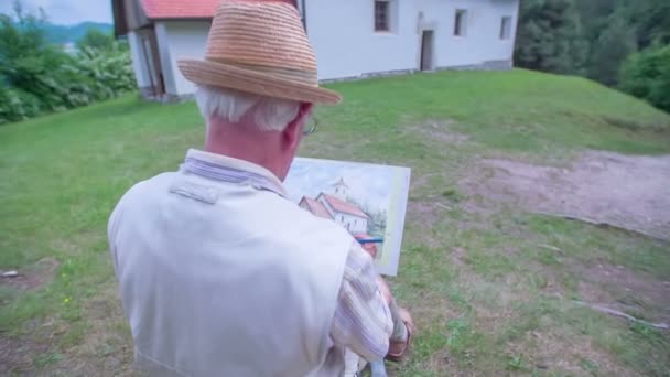 Ein Künstler zeichnet eine Kirche vor sich her - Filmmaterial, Video