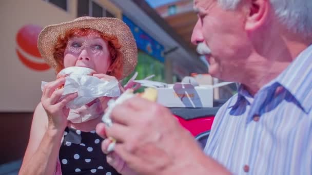 An older couple is biting into their doughnuts - Footage, Video
