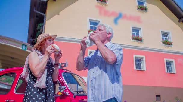 Starsze małżeństwo cieszy się jedzenie pączków - Materiał filmowy, wideo