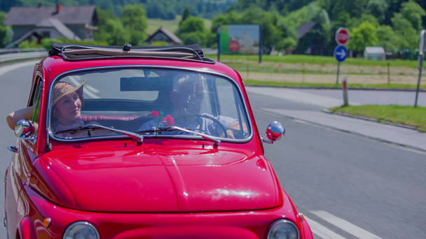 Ein älteres Paar fährt mit seinem roten Yugo - Filmmaterial, Video