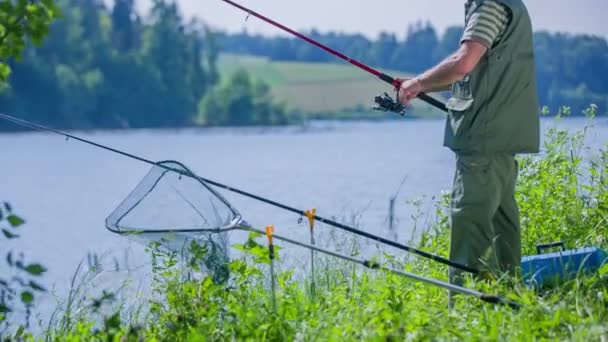 fisherman is slowly spooling the fishing rod - Footage, Video