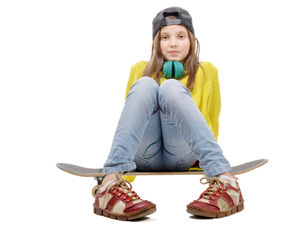  hübsche junge Mädchen posiert mit einem Skateboard, sitzt auf Skate, o - Foto, Bild