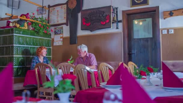 muž a žena jsou rozhovory s ostatními v restauraci - Záběry, video