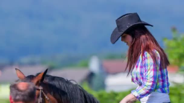 girl is riding a horse accompanied by a horse-breeder - Video, Çekim