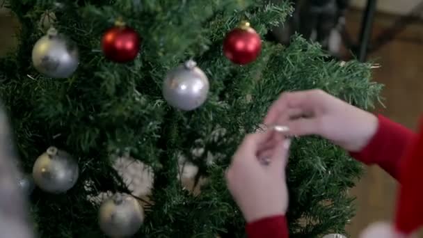 θηλυκό κρέμονται χριστουγεννιάτικα στολίδια - Πλάνα, βίντεο