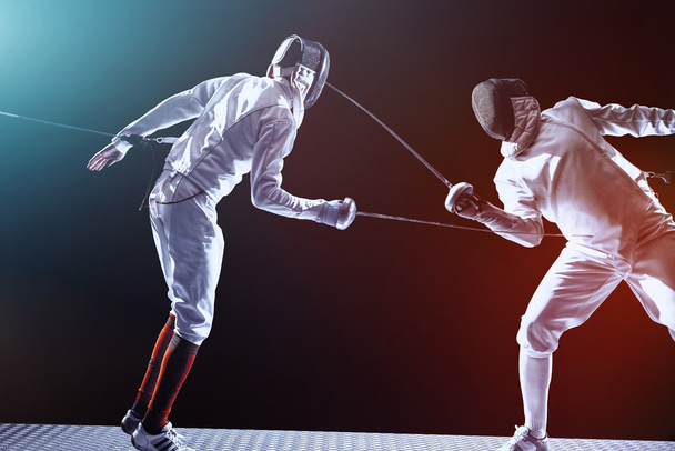 Fencing players isolated on black background - Photo, image