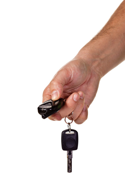 χέρι που κρατά τα κλειδιά του αυτοκινήτου και ένα απομακρυσμένο contro - Φωτογραφία, εικόνα