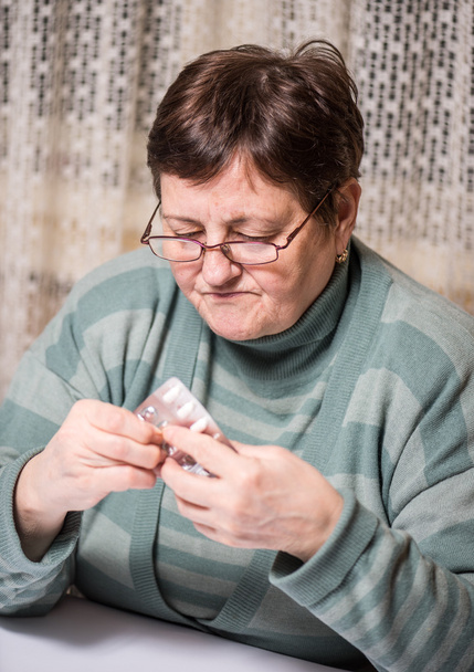 Sad senior woman holding  pills - Fotografie, Obrázek