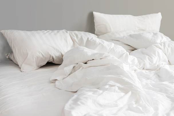 кровать и белые подушки с морщинистым одеялом в спальне, из саней
 - Фото, изображение