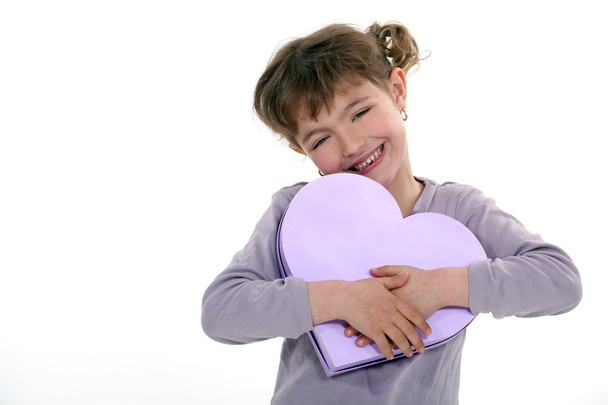 Girl holding a heart-shaped box - Фото, изображение