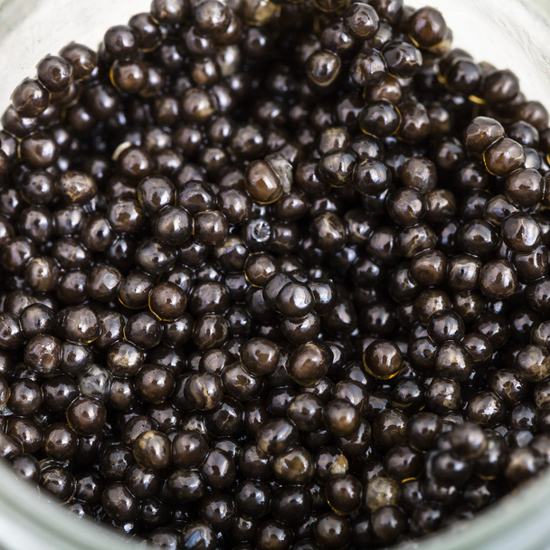 above view of black sturgeon caviar in glass jar - Photo, Image