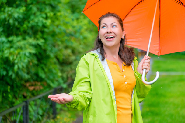 boldog, fiatal nő, egy világos esernyő, várakozás-re a végén rai - Fotó, kép