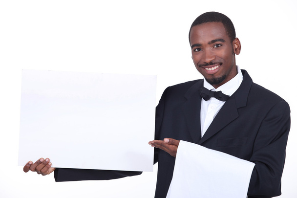 Studio shot of a waiter with a board left blank for your image - Фото, изображение