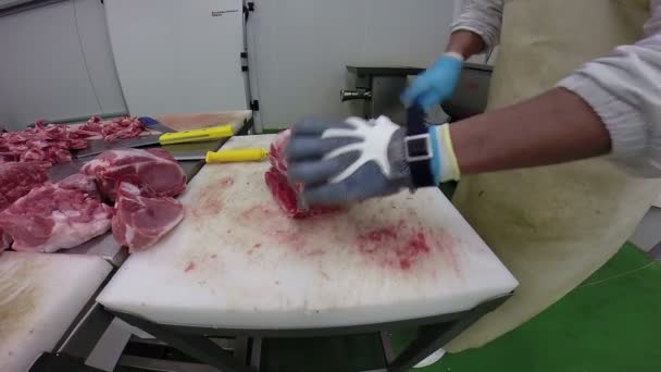 Carnicero cortando carne cruda con cuchilla en matadero
 - Metraje, vídeo