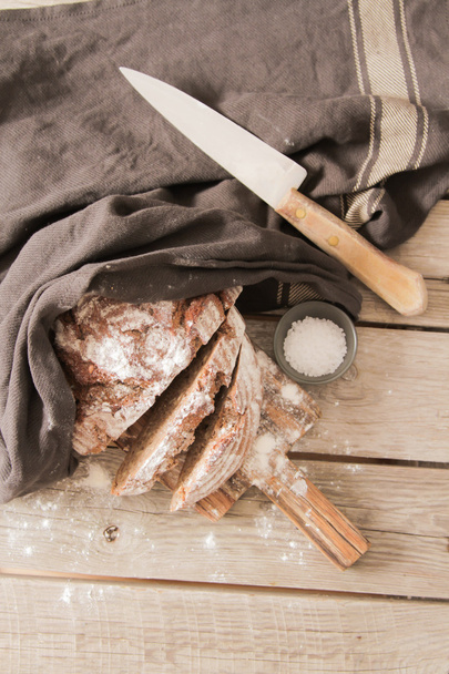 Fresh bread and salt on a wooden background - Photo, image