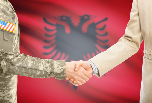 USA military man in uniform and civil man in suit shaking hands with national flag on background - Albania - Fotografie, Obrázek
