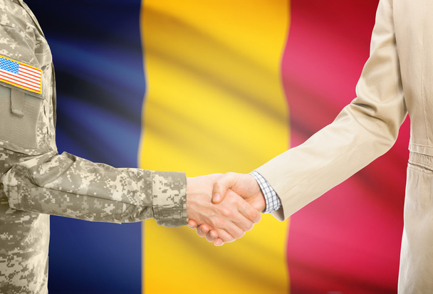 USA military man in uniform and civil man in suit shaking hands with national flag on background - Chad - Fotografie, Obrázek
