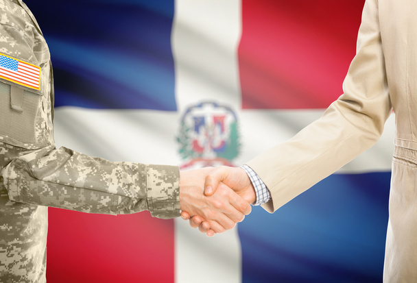 USA military man in uniform and civil man in suit shaking hands with national flag on background - Dominican Republic - Fotografie, Obrázek