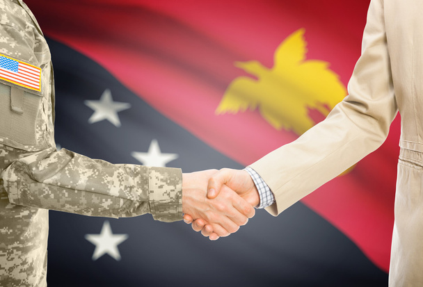 USA military man in uniform and civil man in suit shaking hands with national flag on background - Papua New Guinea - Foto, Imagem
