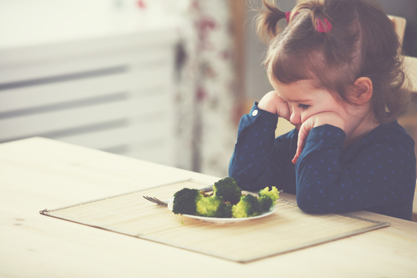 menina criança não gosta e não quer comer legumes
 - Foto, Imagem