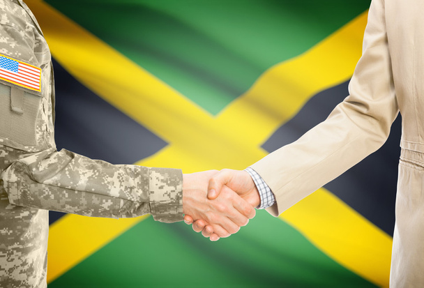 USA military man in uniform and civil man in suit shaking hands with national flag on background - Jamaica - Fotografie, Obrázek