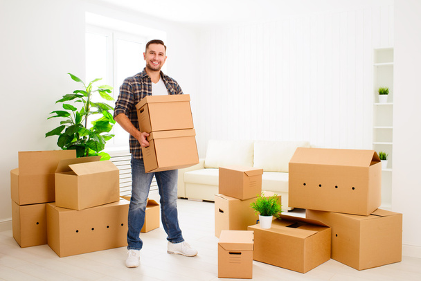 moving to a new apartment. happy man with cardboard boxes - Foto, Imagem