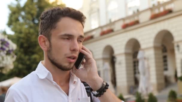 Φοιτητής έχουν μια συνομιλία στο κινητό τηλέφωνο. Close-up πορτρέτο ενός άντρα να μιλάει στο κινητό σε αργή κίνηση. - Πλάνα, βίντεο
