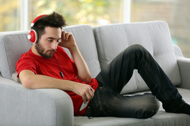 Young man listens music with headphones  - Foto, Imagen