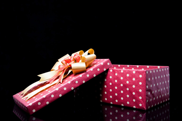 Geïsoleerde polka dot rode doos met boog - Foto, afbeelding