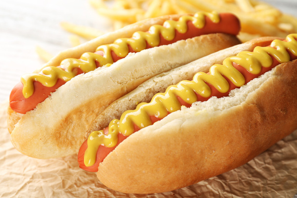 Hot dogs and fried potatoes on wooden background - 写真・画像