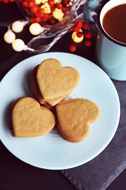 Heart shaped biscuits on plate and mug on a table, top view - Φωτογραφία, εικόνα