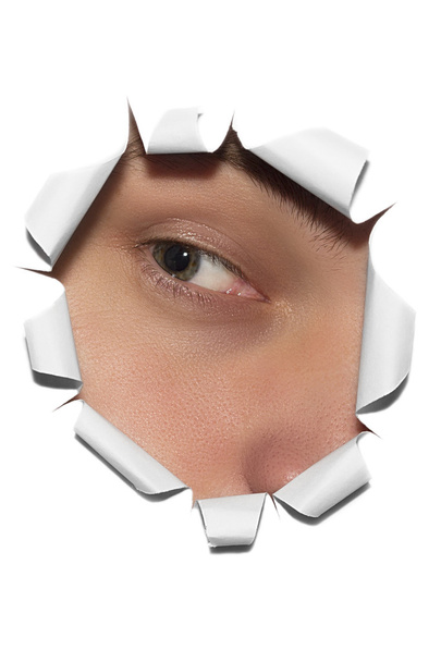 Ojos mirando a través de un agujero en papel
 - Foto, Imagen