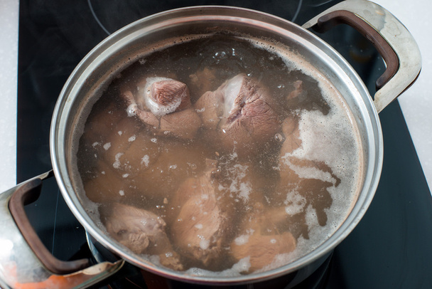 vlees wordt gekookt in kokend water - Foto, afbeelding