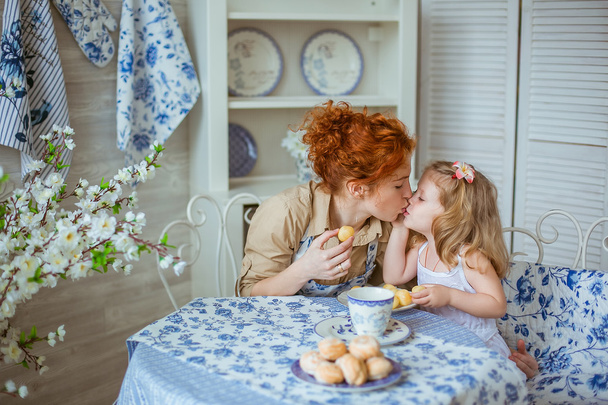 若い母親にキス キッチンで彼女の小さな娘 - 写真・画像