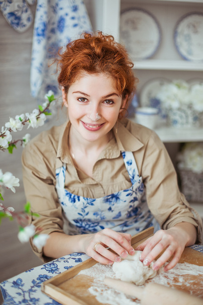 Portrait of a young woman kneads a dough on - Φωτογραφία, εικόνα