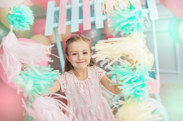 Πορτρέτο του ένα μικρό κορίτσι που κρατά ένα πολύχρωμο γιρλάντες - Φωτογραφία, εικόνα
