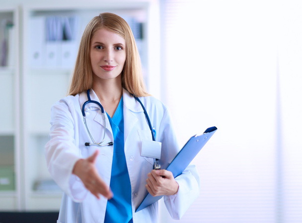 Портрет женщины-врача с папкой в коридоре больницы - Фото, изображение