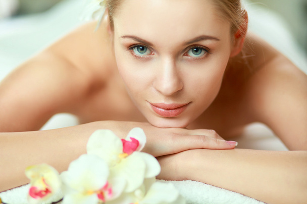 Schöne junge Frau bekommt Wellness-Massage, liegend im Salon - Foto, Bild