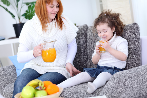 Mother and daughter drinking orange juice - Zdjęcie, obraz