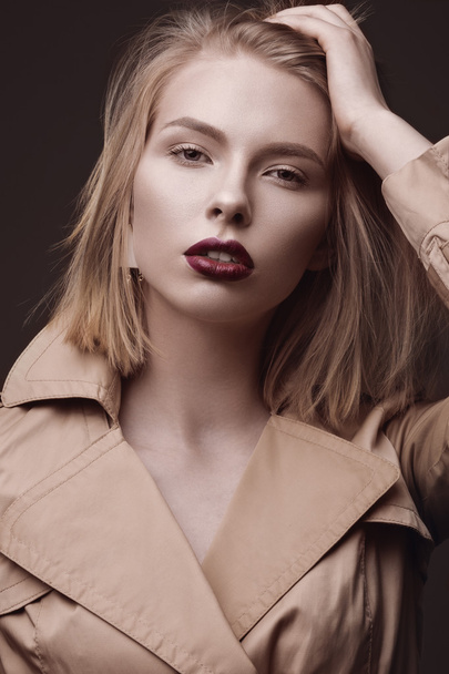 Beautiful blonde woman in a bright coat and dark lips, showing different poses. Beauty face. - Fotó, kép