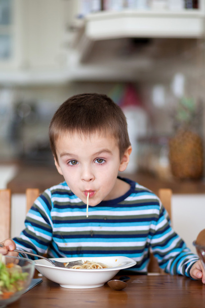 Cute little boy, eating spaghetti at home for lunchtime - Foto, Imagen