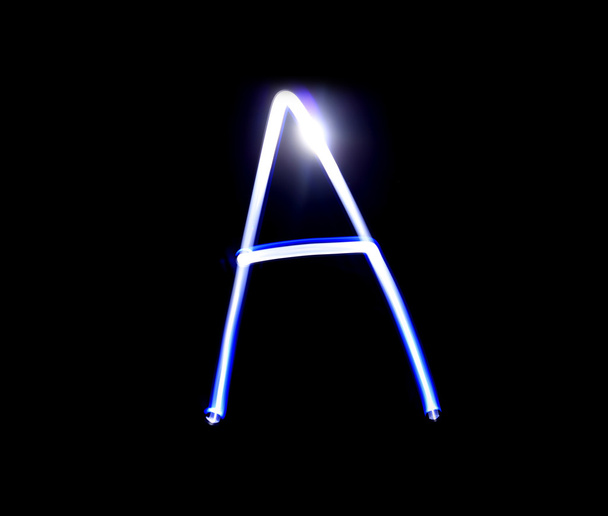 Способный алфавит, пишущий синий свет на черном фоне
. - Фото, изображение