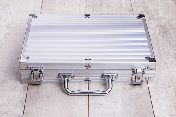металлический чемодан на деревянном фоне
 - Фото, изображение
