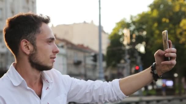 Aantrekkelijke man in zijn 20s nemen van panorama foto met behulp van zijn smartphone buitenshuis - Video